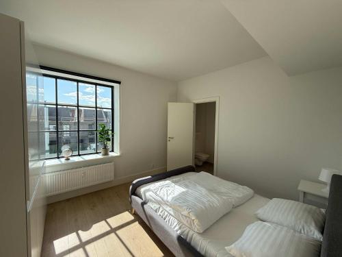 a bedroom with a bed and a window at Cozy Odense Apartment Long Term Stay in Odense