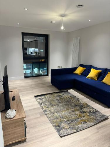 a living room with a blue couch and yellow pillows at Apartment with Terrace in Uxbridge in Uxbridge