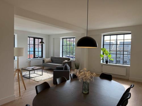 a living room with a table and a couch at Modern & Stylish Serviced Apartment in Odense in Odense