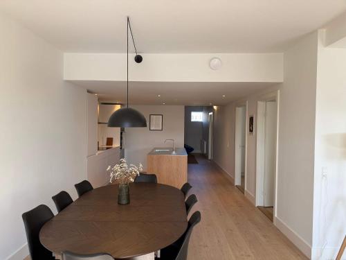 a dining room and kitchen with a table and chairs at Modern & Stylish Serviced Apartment in Odense in Odense