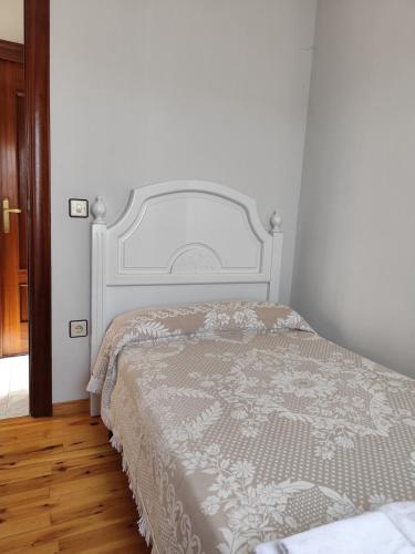 a bedroom with a bed with a white bedspread at El Solano-La Gallega in La Gallega