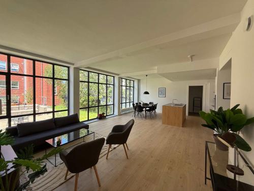 an open living room with a couch and chairs at Central Odense Lovely Apartment in Odense