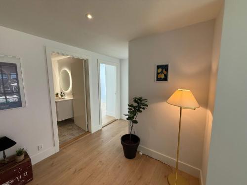 a living room with a plant and a lamp at Central Odense Lovely Apartment in Odense