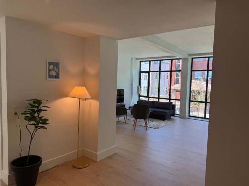 a living room with a couch and a lamp in it at Central Odense Lovely Apartment in Odense