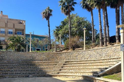 un conjunto de escaleras frente a un edificio con palmeras en House -Sleeps 6-Garden-Fireplace, en Alicante