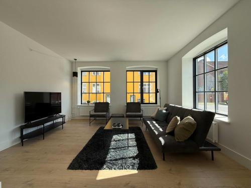 a living room with a couch and a flat screen tv at Luxurious Odense Residence in Odense