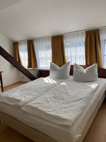 a bed with white sheets and pillows in a bedroom at Landgasthaus Jahnsfelde in Müncheberg