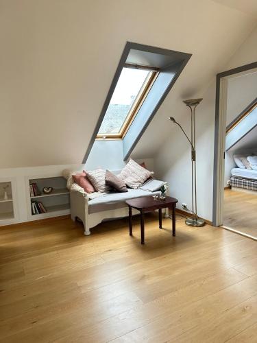 a living room with a couch and a window at Bright loft apartment in a Jugend-style courtyard close to the Sound of Brosund in Ålesund