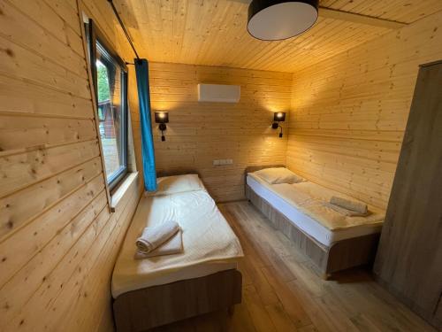 a room with two beds in a wooden cabin at Hotel Zielony & OW Borowik & Pensjonat Manhattan - Centrum Rekreacji i Wypoczynku GASTROTUR in Turawa