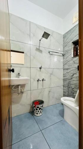 a bathroom with a sink and a toilet and a tub at Rams Guest House Meadows Walk to Varkala Papnasam Beach - Groups & Couple friendly in Varkala