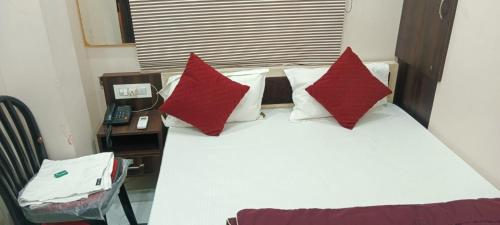 a bedroom with a bed with red pillows and a telephone at !! AYODHYA HOTEL PRINCE #Fully Air Conditioning Rooms #Free Wi-Fi #Parking #Room Service #Premium Room #Best Hotel In Ayodhya !! in Ayodhya