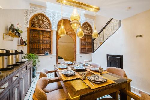 a dining room with a wooden table and chairs at Riad Emeraude Cozy Riad with Shared Pool 4 Room in Marrakech