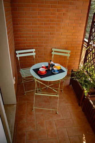 a table with bowls and plates on it on a patio at Sky Blue Rooms in Bastia Umbra