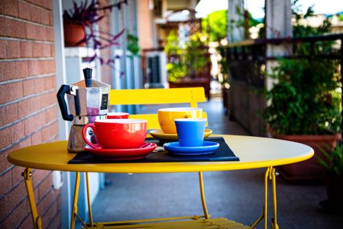 a yellow table with cups and coffee cups on it at Sky Blue Rooms in Bastia Umbra