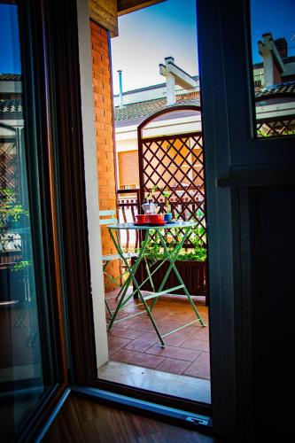 a table and a chair on a patio outside a window at Sky Blue Rooms in Bastia Umbra