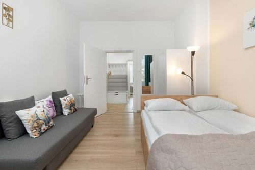 een woonkamer met twee bedden en een bank bij Five Bedroom Apartment for 12 in Gdańsk Center with Desk and Balcony by Noclegi Renters in Suchanino