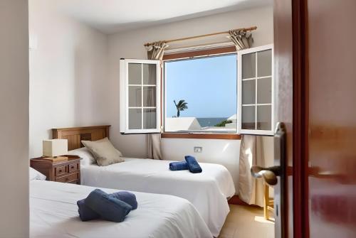 1 dormitorio con 2 camas y ventana con vistas en Villa Turqué, en Arrieta