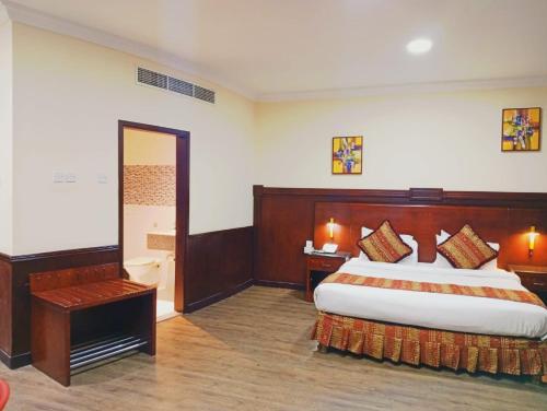 a hotel room with a bed and a desk at Ramee California Hotel in Manama