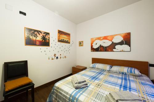 sypialnia z łóżkiem i zdjęciami na ścianie w obiekcie Domus al Parco Guest House w mieście Fiumicino