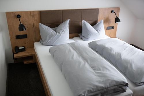 two beds with white sheets and pillows at Landgasthof Kinzigstrand in Biberach bei Offenburg