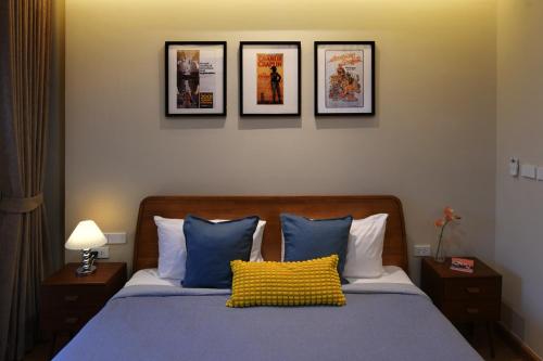 1 dormitorio con 1 cama con 4 cuadros en la pared en Pillow & Paper, en Bangkok