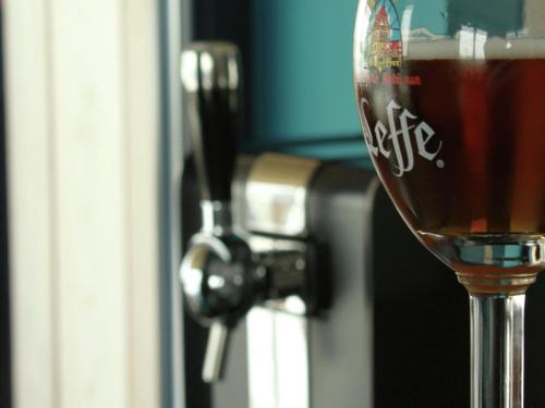 a glass of wine sitting in front of a door at Modern Cottage in Vaux-sur-Sûre with Sauna in Morhet