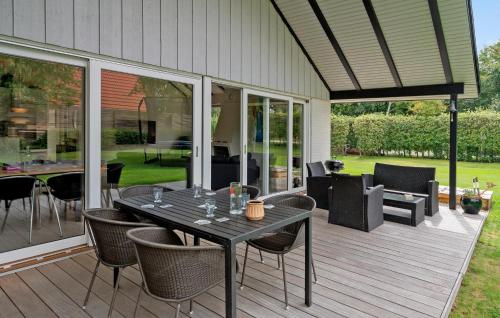 a patio with a table and chairs on a deck at 3 Bedroom Amazing Home In Lundby in Lundby