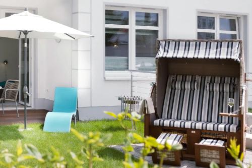 a bed in the yard of a house with an umbrella at Villa Wiederkehr Einkehr in Ostseebad Sellin