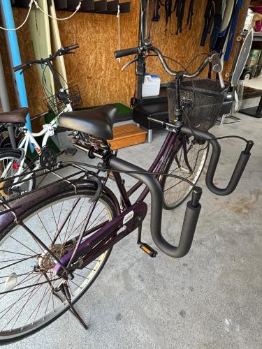 a purple bike with a basket and a book on it at MATAHARI Guesthouse in Miyazaki