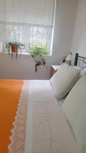 a white bed in a bedroom with a window at Xhumba Guesthouse in Dhuvjan