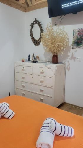 a bedroom with a dresser and a table with a bed at Xhumba Guesthouse in Dhuvjan
