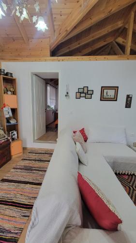 a large white couch in a room with a bed at Xhumba Guesthouse in Dhuvjan