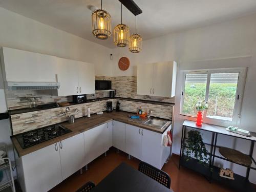a kitchen with white cabinets and a sink and a window at Antonia Rural House in Tacoronte