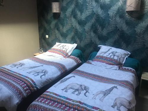 two beds sitting next to each other in a bedroom at La PASSUITIÈRE in Saint-Mesmin