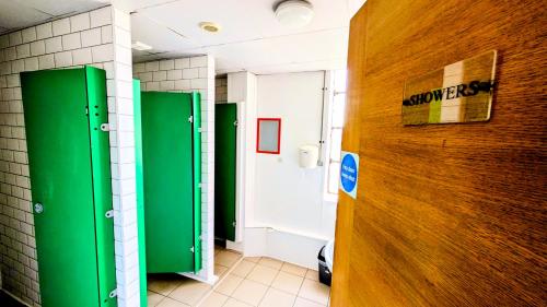 a bathroom with green and white walls and a door at Rest Up London in London