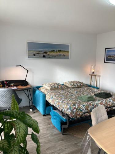 a bedroom with a bed and a desk and a table at Résidence le 46 in Concarneau