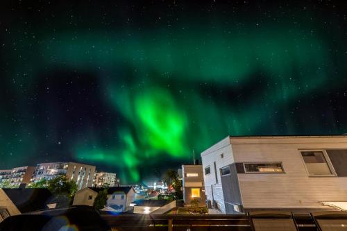 an image of the northern lights in the sky at Kais sauna, jacuzzi, cinema and balcony house! Central location in Tromsø