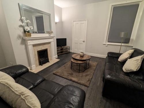a living room with a couch and a fireplace at Town Hall Property in South Shields