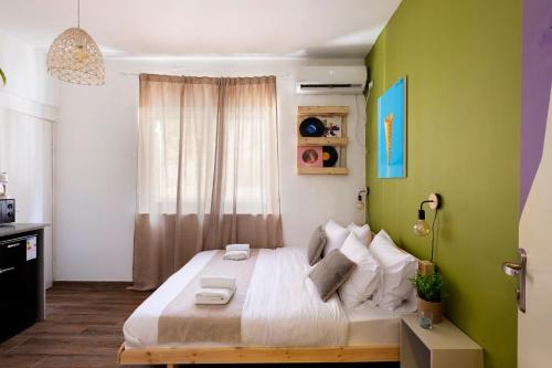 a bedroom with a large bed with green walls at Rena's House - Beach Edition in Tel Aviv