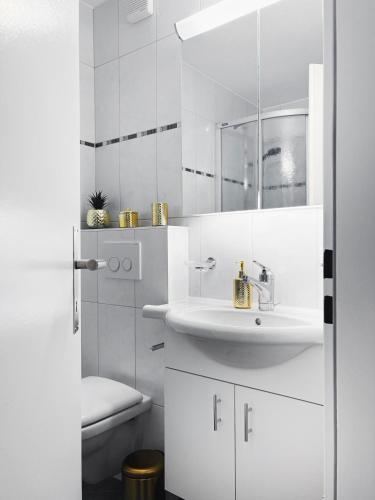 a white bathroom with a sink and a toilet at Valere C 244 in Leukerbad