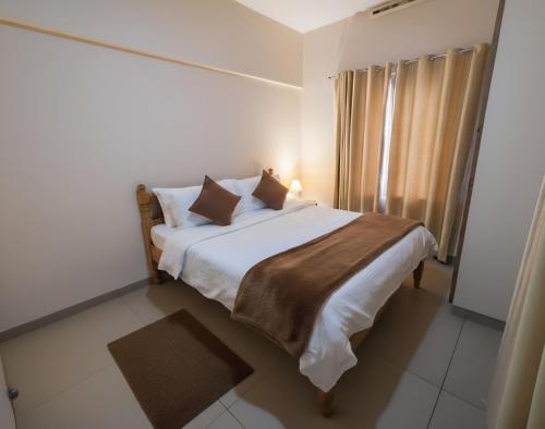 a bedroom with a bed with white sheets and pillows at Anand homestay in Kattappana