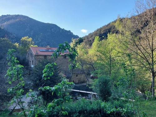 una casa en medio de una montaña con un río en Big Gite, en Amélie-les-Bains-Palalda