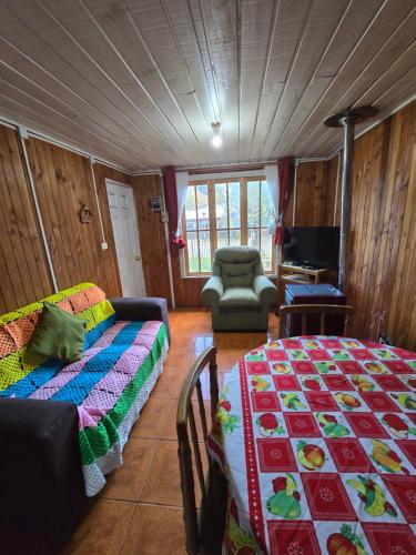 a living room with a bed and a couch at Cabaña 4 personas in Coñaripe