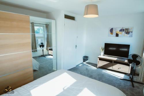 a living room with a bed and a television at Modern 2 bedroom Terrace in Woolwich