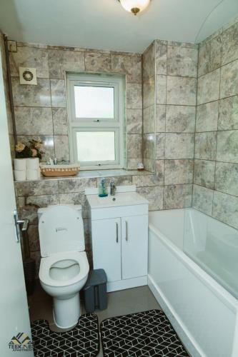 a bathroom with a toilet and a sink and a tub at Modern 2 bedroom Terrace in Woolwich