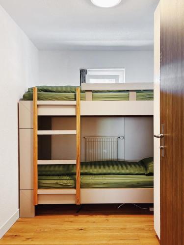 two bunk beds in a room with green sheets at Valere C 244 in Leukerbad