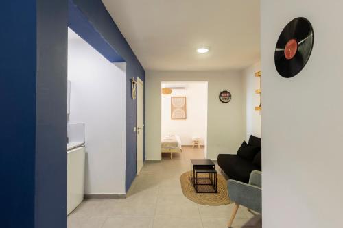 a living room with a black couch and a blue wall at Rena's House - Beach Edition in Tel Aviv