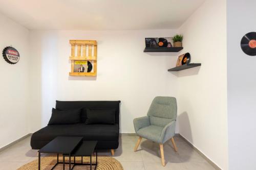 a living room with a couch and a chair at Rena's House - Beach Edition in Tel Aviv