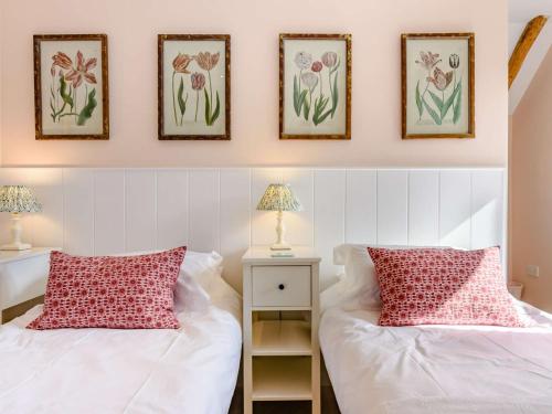 two beds in a bedroom with three pictures on the wall at 2 Bed in Goudhurst 51229 in Goudhurst
