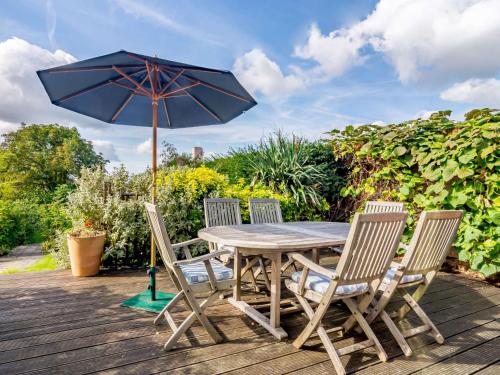 a wooden table with four chairs and an umbrella at 2 Bed in Goudhurst 51229 in Goudhurst